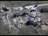 The second image depicting tornado damage in a field.